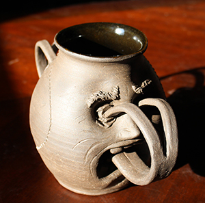 A phantasmagoric vase with a forked tongue that stabs it in the eyes serving as handles